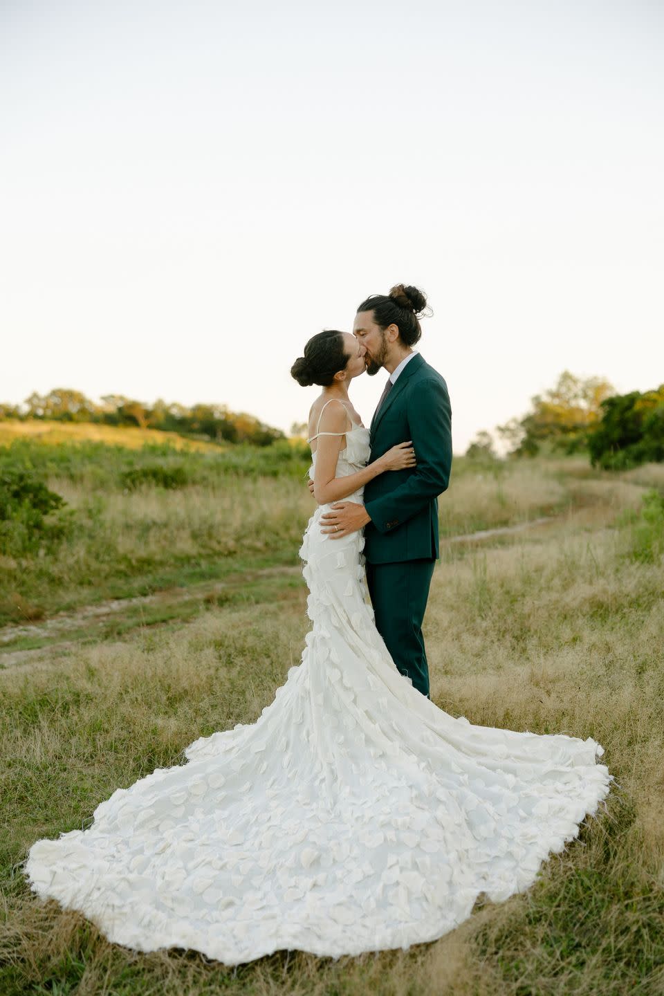 a man and woman kissing on a dirt road