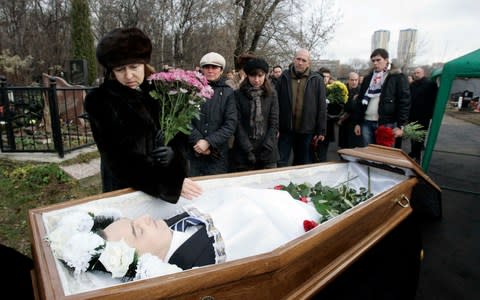 Nataliya Magnitskaya (L), mother of Sergei Magnitsky, grieves over her son 's body during his funeral at a cemetery in Moscow  - Credit: Reuters