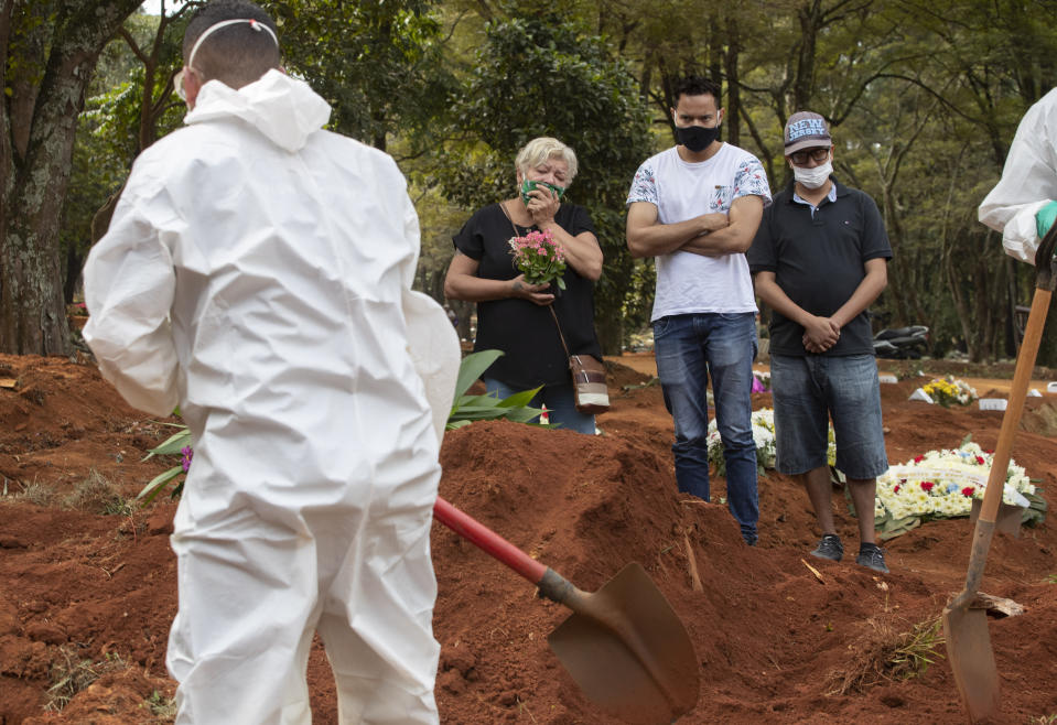 Relatives attend the burial of the remains of a person suspected to have died of COVID-19 disease, at the Vila Formosa cemetery in Sao Paulo, Brazil, Thursday, April 30, 2020. (AP Photo/Andre Penner)