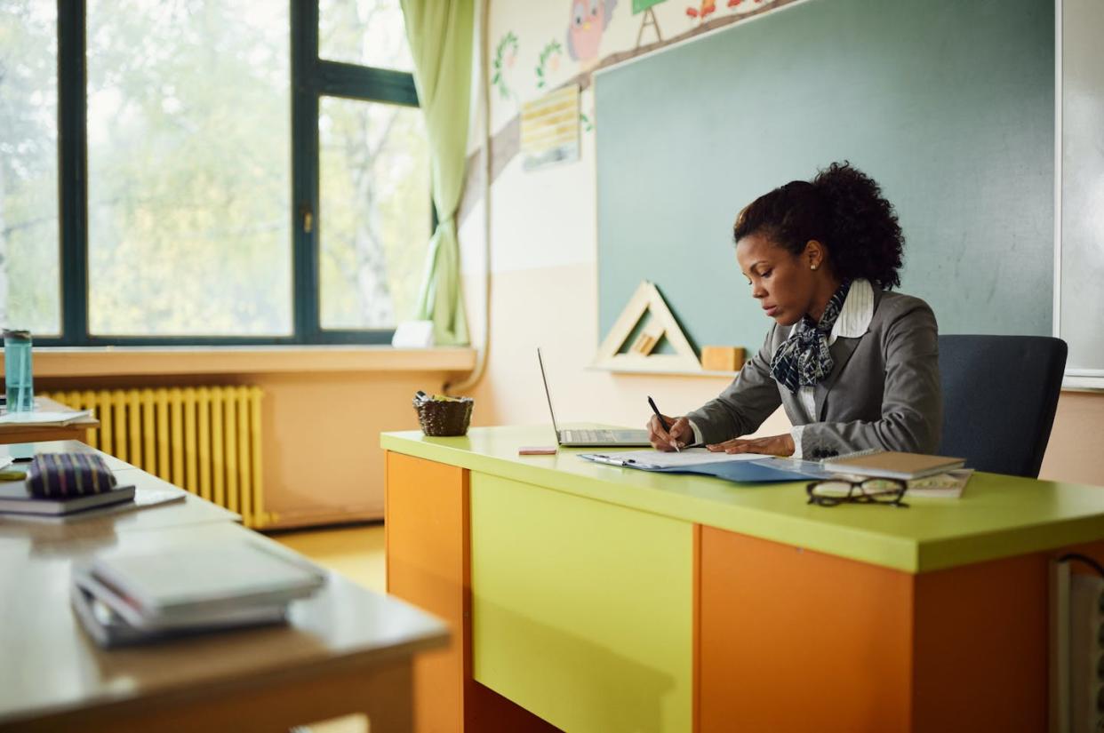 Some teachers are resisting efforts to give students grades they believe they haven't earned. <a href="https://www.gettyimages.com/detail/photo/african-american-teacher-writing-her-plans-in-the-royalty-free-image/1447095036?phrase=teachers+grading+papers&adppopup=true" rel="nofollow noopener" target="_blank" data-ylk="slk:skynesher via Getty Images;elm:context_link;itc:0;sec:content-canvas" class="link ">skynesher via Getty Images</a>