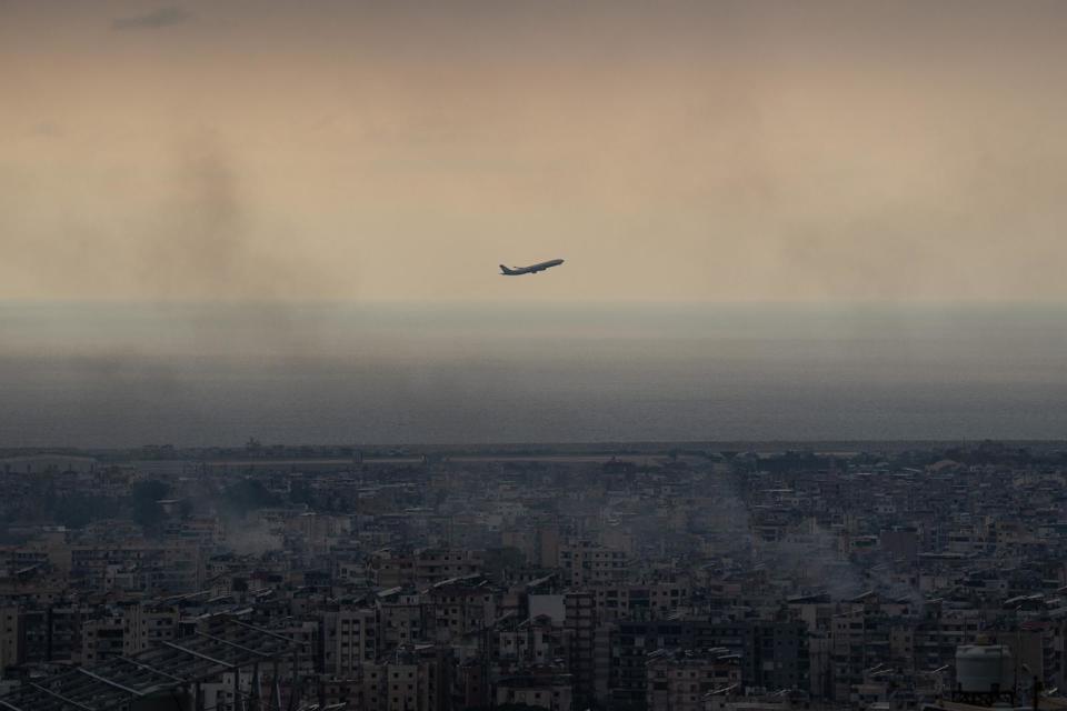 PHOTO: A plane departing Beirut international airport flies near smoke from Israeli airstrikes on Oct. 6, 2024 in Beirut, Lebanon. (Carl Court/Getty Images)