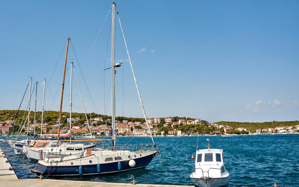 Yachts moored by the strait dividing mainland and Murter island, Tisno, Croatia - Getty