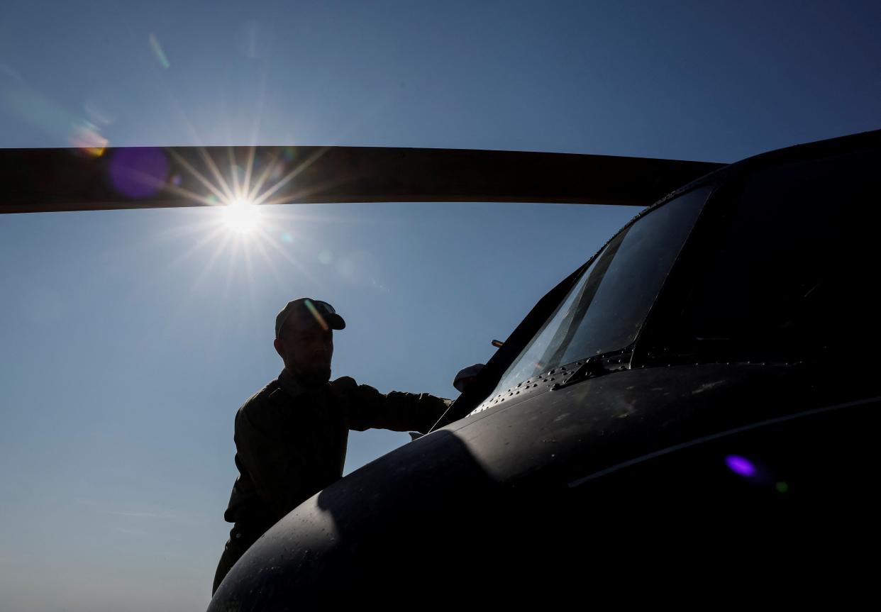 A serviceman services a helicopter after a mission (REUTERS)