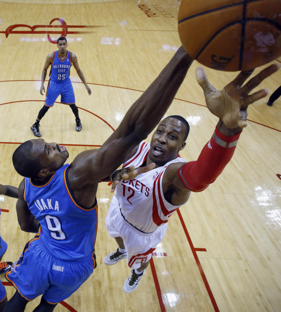 Houston Rockets' Dwight Howard (12) shoots as Oklahoma City Thunder's Serge Ibaka (9) defends during the first quarter of an NBA basketball game, Thursday, Jan. 16, 2014, in Houston. (AP Photo/David J. Phillip)