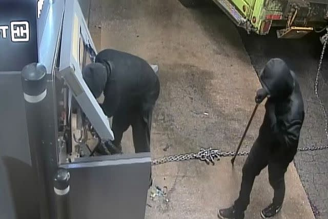 <p>Jefferson County Sheriff's Office</p> The two thieves are depicted in the process of hooking up the ATM machine to the garbage truck, Feb. 12.