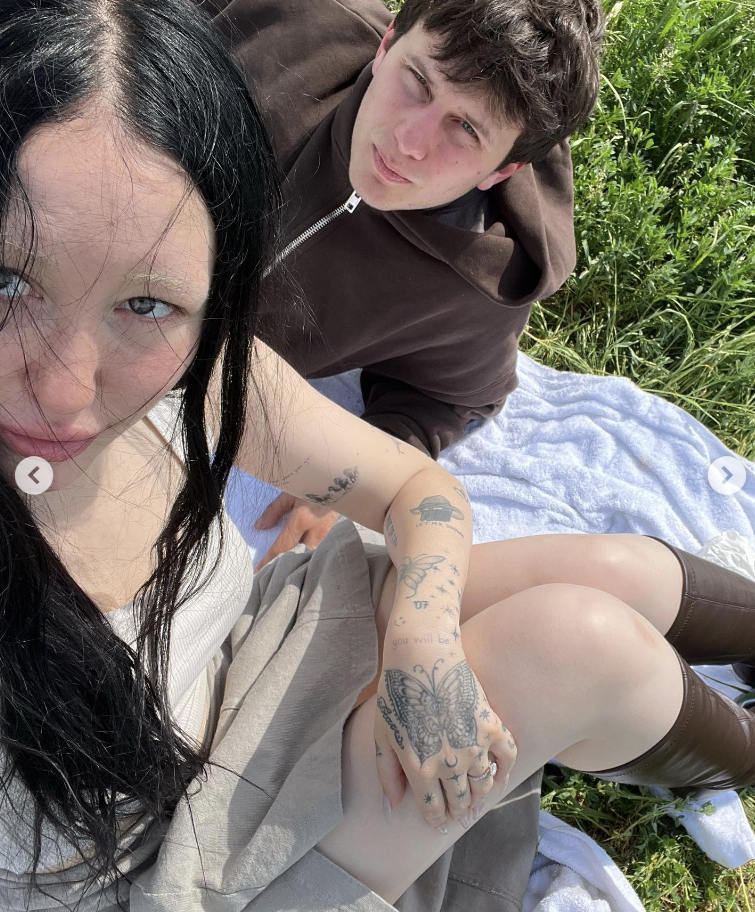 Noah Cyrus and Pinkus sit on a blanket on green grass and take a selfie. (Noah Cyrus / Instagram)