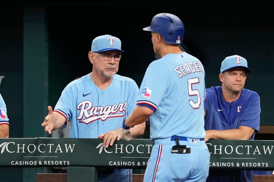 Rangers manager Bruce Bochy, left, celebrates with shortstop Corey Seager after Seager's home run against the Brewers.