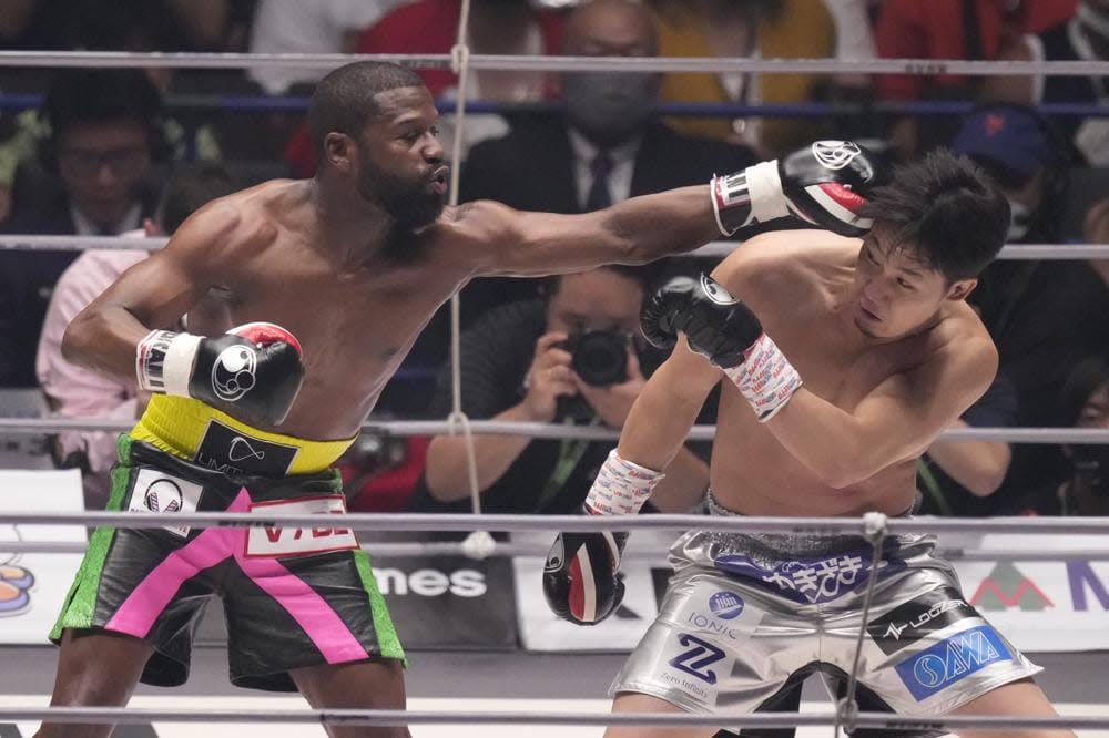 Boxer Floyd Mayweather of the U.S. throws a punch against mixed martial artist Mikuru Asakura of Japan in Saitama, north of Tokyo, Sunday, Sept. 25, 2022. (AP Photo/Hiro Komae)