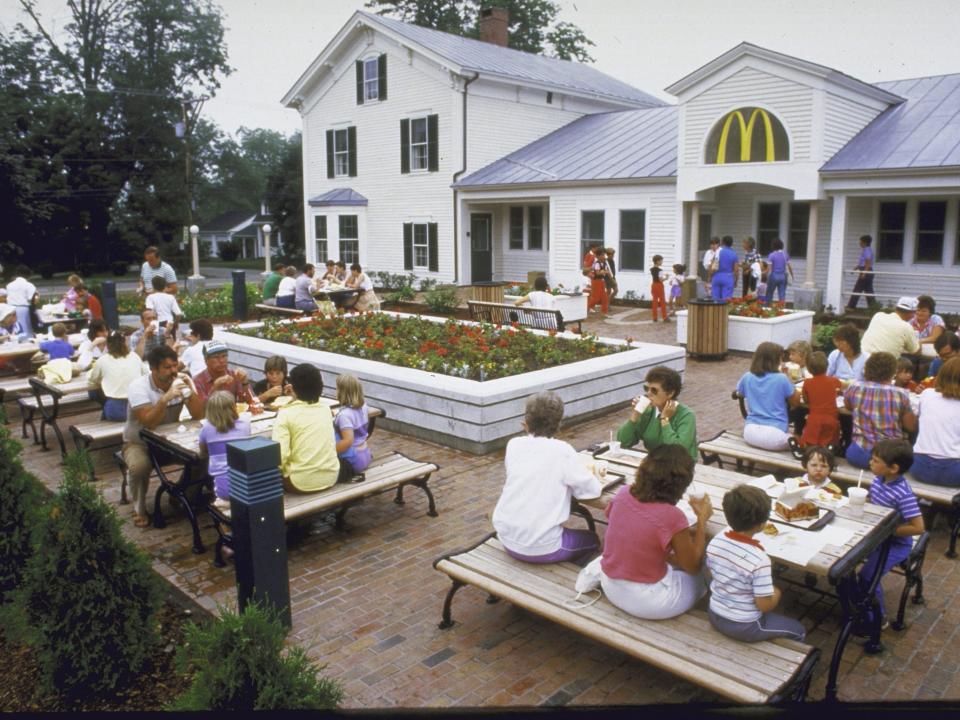 McDonald's restaurant is seen from outside where people eat outdoors at picnic tables in August 1985