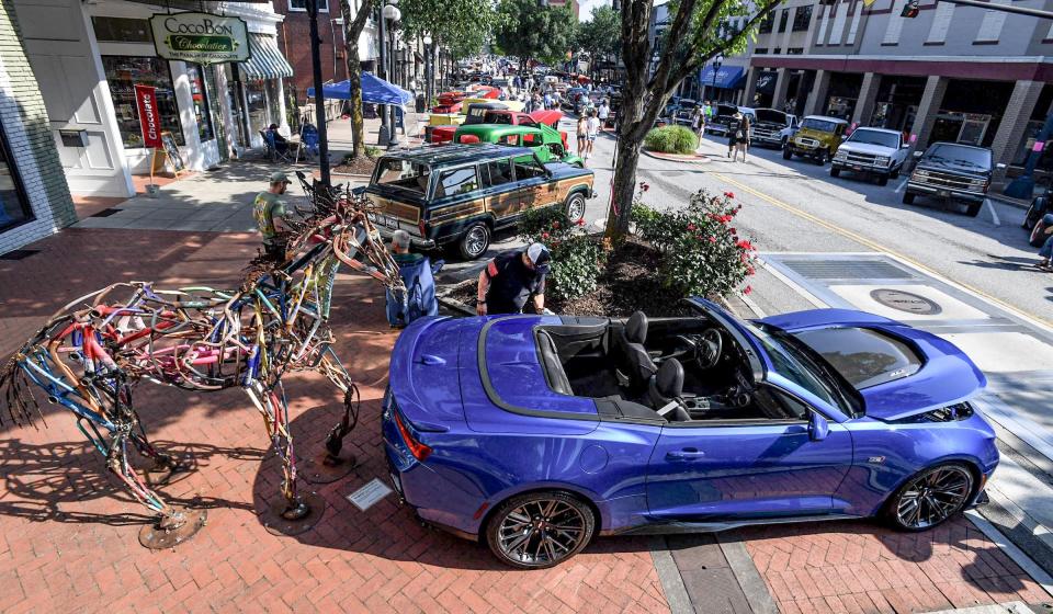 Alan Johnson of Anderson shines his 2018 ZLI Camero, with 650 horsepower, parked near a statue of a horse, during the Main Street Program's 24th annual Piedmont Natural Gas Day B4 Father's Day Car Show in Anderson, S.C. Saturday, June 15, 2024. 