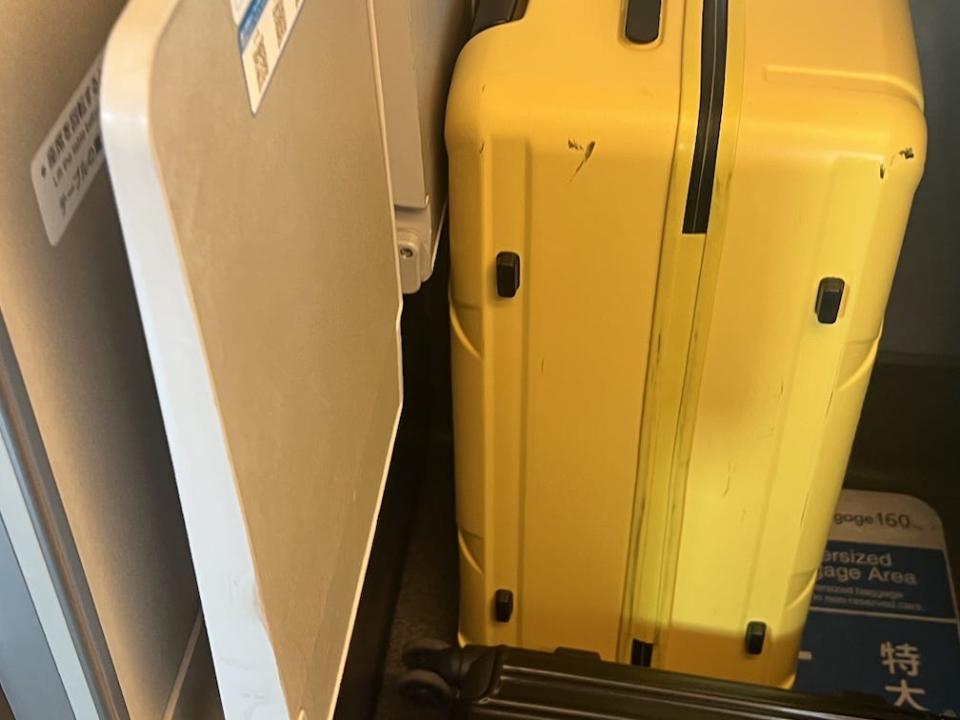 A yellow suitcase in the space behind one of the seats.