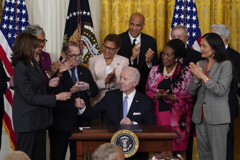 President Joe Biden hands a pen to Vice President Kamala Harris after signing an executive order in the East Room of the White House, Wednesday, May 25, 2022, in Washington. The order comes on the second anniversary of George Floyd's death, and is focused on policing. (AP Photo/Alex Brandon)