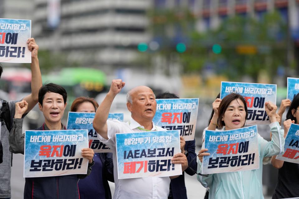 Members of civic groups shout slogans during a rally to oppose Japanese government's decision to release treated radioactive water into the sea from the Fukushima nuclear power plant, in Seoul, South Korea, Wednesday, July 5, 2023. The letters read "Abolish a report of the IAEA."