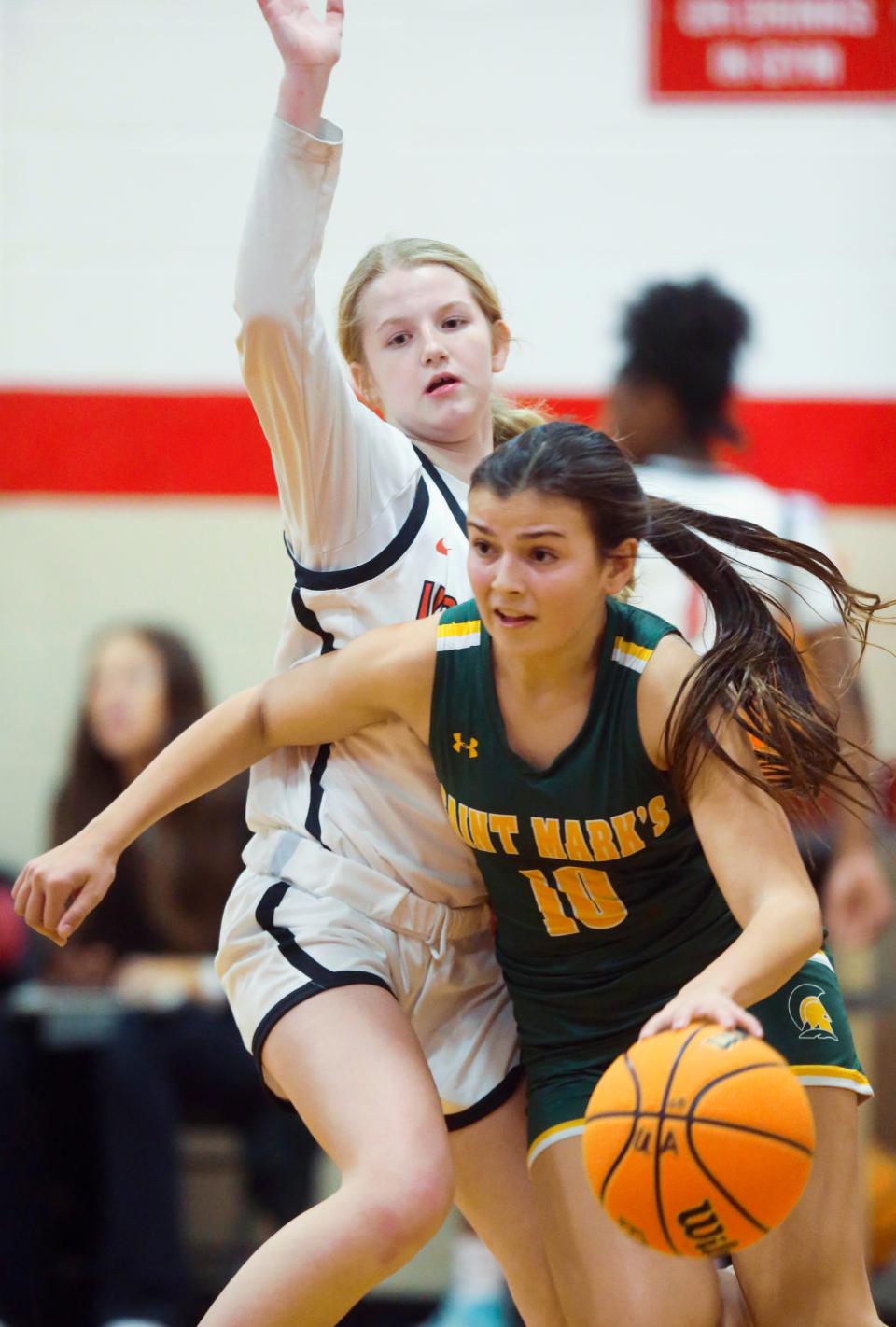 Ursuline's Emma Anthony (left) defends as St. Mark's Sophia Baffone drives in the first half of the Raiders' win, Thursday, Jan. 19, 2023 at Ursuline Academy.