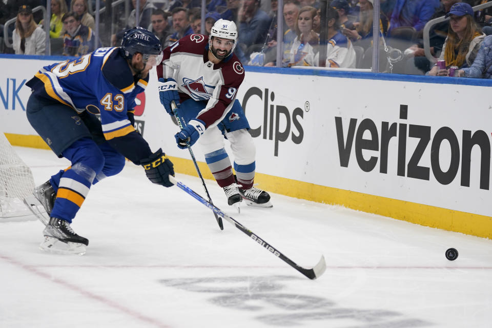 Colorado Avalanche's Nazem Kadri (91) and St. Louis Blues' Calle Rosen (43) chase after a loose puck along the boards during the first period in Game 4 of an NHL hockey Stanley Cup second-round playoff series Monday, May 23, 2022, in St. Louis. (AP Photo/Jeff Roberson)