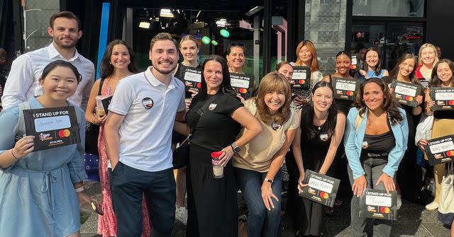 <p>Mastercard</p> On July 16, Mastercard employees and partners celebrate their collaboration with Stand Up To Cancer, holding up placards in New York’s Times Square to honor someone they love impacted by cancer.