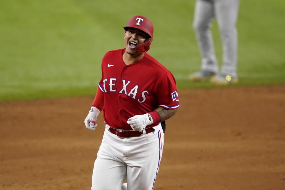 Texas Rangers' Yohel Pozo smiles as he rounds the bases on the way home after hitting a three-run home run in the sixth inning of the team's baseball game against the Oakland Athletics in Arlington, Texas, Friday, Aug. 13, 2021. The shot, that came off of relief pitcher Sergio Romo, scored Andy Ibanez and Jason Martin. (AP Photo/Tony Gutierrez)