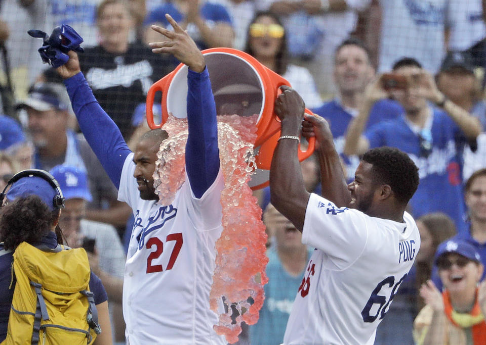 Los Angeles Dodgers' Matt Kemp, left, is doused by teammate Yasiel Puig after Kemp's two-run walk-off double against the Arizona Diamondbacks during a baseball game Sunday, Sept. 2, 2018, in Los Angeles. Los Angeles won 3-2. (AP Photo/Marcio Jose Sanchez)