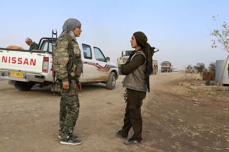 Kurdish People's Protection Units (YPG) and Kurdistan Workers Party (PKK) fighters man a checkpoint on a highway connecting the Iraqi-Syrian border town of Rabia and the town of Snuny north of Mount Sinjar December 20, 2014. REUTERS/Massoud Mohammed