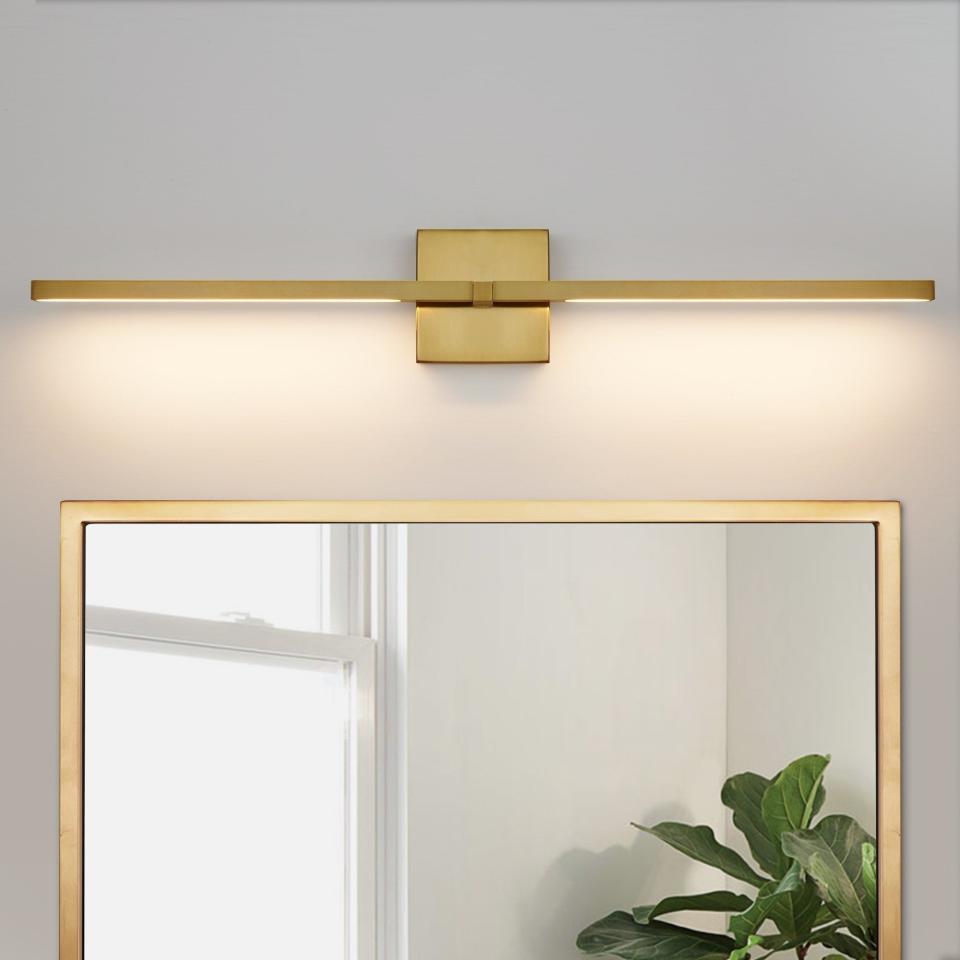 Modern wall-mounted light fixture above a mirror, providing soft illumination suitable for a chic interior. Perfect for bathroom vanity lighting