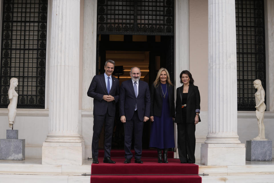 Greece's Prime Minister Kyriakos Mitsotakis, left, his Armenian counterpart Nikol Pashinyan, second left, their wives Mareva Grabowski-Mitsotakis, second right, and Anna Hakobyan pose before their meeting at Maximos Mansion in Athens, Greece, Tuesday, Feb. 27, 2024. (AP Photo/Thanassis Stavrakis)