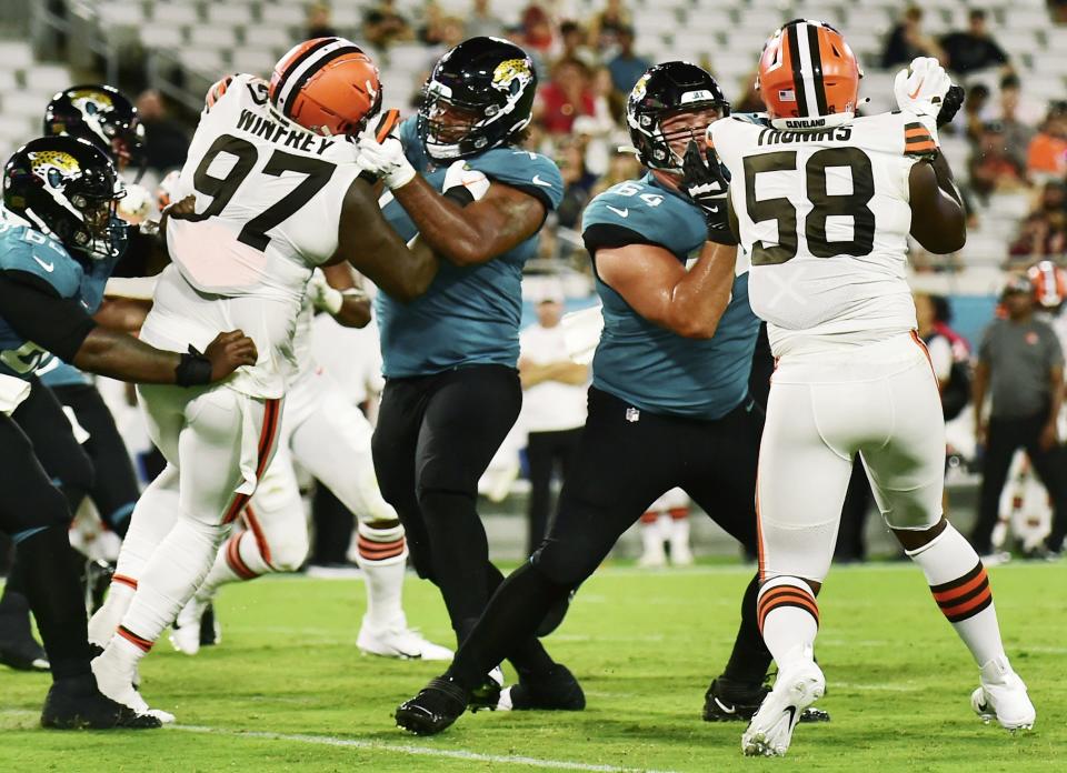 Jacksonville Jaguars center Nick Ford (77) and offensive tackle Coy Cronk (64) hold back Cleveland Browns defensive tackle Perrion Winfrey (97) and defensive end Isaiah Thomas (58) during an unsuccessful Jaguars pass play late in fourth quarter action. The Jacksonville Jaguars hosted the Cleveland Browns at TIAA Bank Field in Jacksonville, Florida Friday, August 12, 2022 for the first home preseason game of the season. The Browns won with a final score of 24 to 13. [Bob Self/Florida Times-Union]