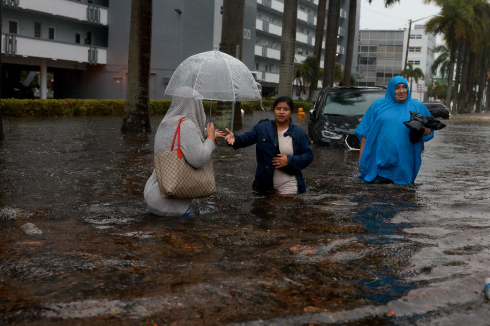 People walk through a flooded street on June 12, 2024, in Hollywood, Florida. As tropical moisture passes through the area, areas have become flooded due to the heavy rain. / Credit: Getty Images