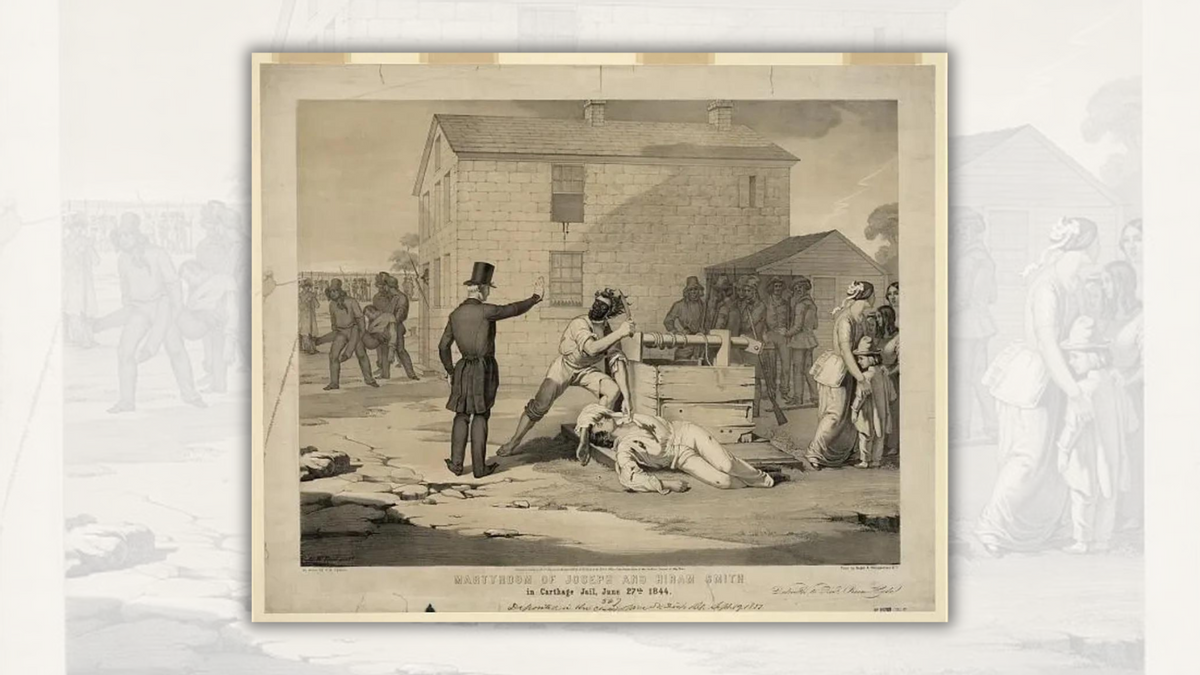 A person holds up their hand to stop another person holding a knife in one hand and touching a man lying on the ground with a knife wound with the other. People surrounding the three are either watching or moving away from the scene. 