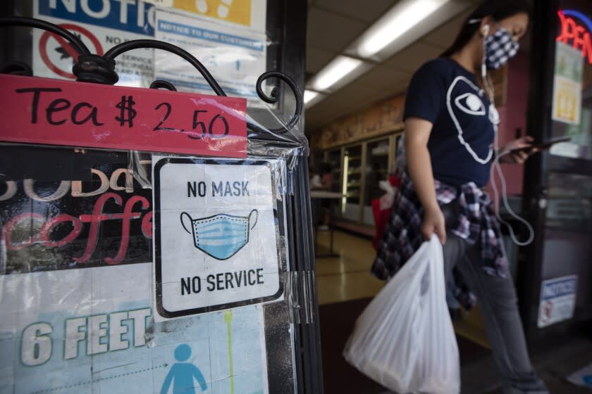 LOS ANGELES, CA - JULY 17: A sign at a Chinatown business reminds customers to wear a mask. The LA County mask mandate will go into effect at 11:59 p.m. Saturday, July 17, 2021 requiring masks be worn indoors with the exception that masks can be removed if dining in a restaurant. Photographed in Chinatown on Saturday, July 17, 2021 in Los Angeles, CA. (Myung J. Chun / Los Angeles Times)