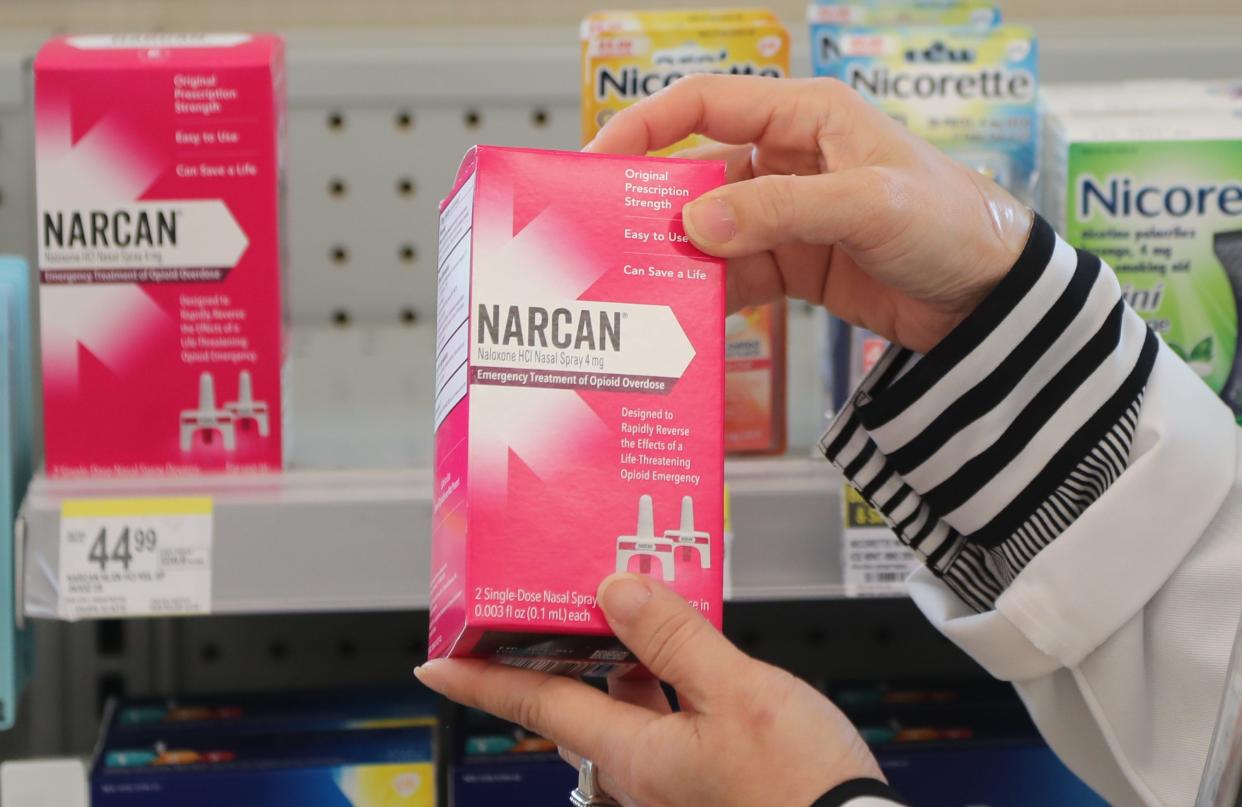 Allison Nguyen, Pharmacy Manager, holds a box of Narcan, which is available behind the check out counter at Walgreens at Habersham Village on Monday, March 25, 2024.