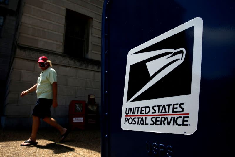 A man walks by a United States Postal Service (USPS) mailbox in downtown Washington