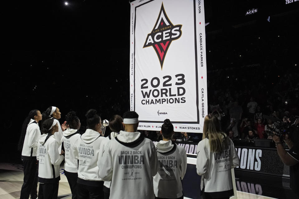 Las Vegas Aces players watch as they raise the 2023 championship banner before a WNBA basketball game Tuesday, May 14, 2024, in Las Vegas. (AP Photo/John Locher)