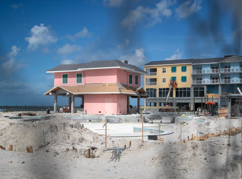 Workers install shutters on the beach side building near the pool at the Margaritaville Beach Resort on Fort Myers Beach on Monday, Aug. 21, 2023.