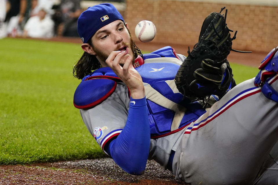 Texas Rangers catcher Jonah Heim bobbles a foul ball by Baltimore Orioles' Robinson Chirinos on a bunt attempt during the 10th inning of a baseball game, Tuesday, July 5, 2022, in Baltimore. Heim was able to catch the ball to make the out. The Orioles won 10-9 in ten innings. (AP Photo/Julio Cortez)