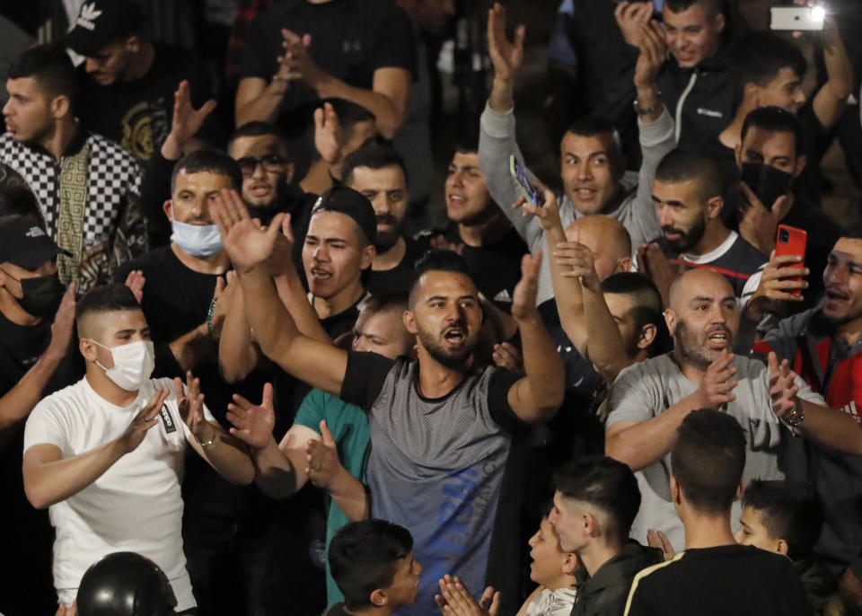 Palestinians shout slogans in a plaza outside of Jerusalem's Old City, Sunday, April 25, 2021. Israeli police late Sunday removed barricades outside Jerusalem's Old City that had prevented Muslims from meeting in a traditional gathering spot during the holy month of Ramadan. The barricades have sparked nightly clashes between Palestinian protesters and Israeli police, and their removal appeared to be aimed at easing the tensions. (AP Photo/Ariel Schalit)