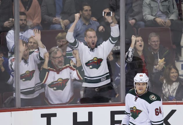 Fans celebrate after Minnesota Wild’s Mikael Granlund, of Finland, scored his third goal against the Vancouver Canucks, during the third period of an NHL hockey game Saturday, Feb. 4, 2017, in Vancouver, British Columbia. (Darry Dyck/The Canadian Press via AP)
