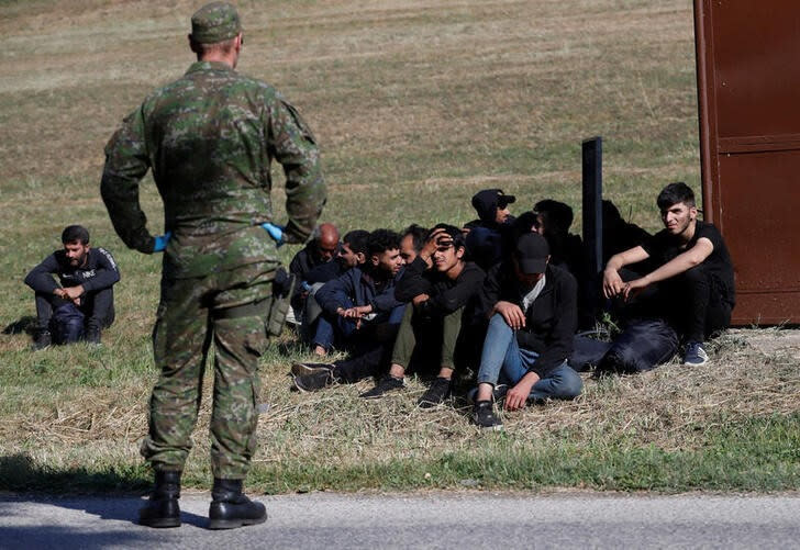 Migrants wait, as they are detained by Slovakian police, after illegally crossing the border close to the Slovakia-Hungary border in the village of Chl'aba