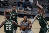 San Antonio Spurs forward Keldon Johnson (3) looks to score against Milwaukee Bucks defenders Khris Middleton (22), Giannis Antetokounmpo (34) and Brook Lopez (11) during the second half of an NBA basketball game in San Antonio, Monday, May 10, 2021. (AP Photo/Eric Gay)