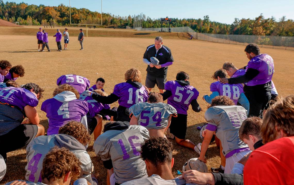 Walhalla football coach Padgett Johnson prays with his team before practice at the school. Johnson has volunteered to coach the 3-A Razorback football team for the past seven seasons.