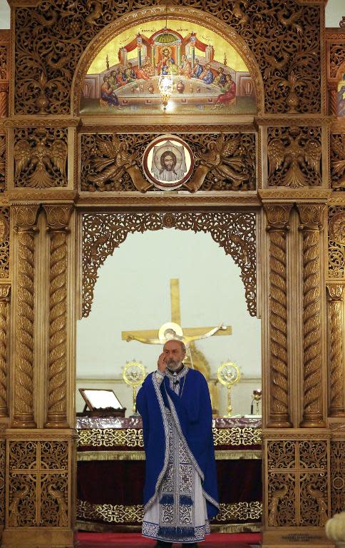 A Syrian Christan priest performs a mass at the Greek Orthodox church in the Syrian government controlled area in the northern city of Aleppo on November 16, 2014