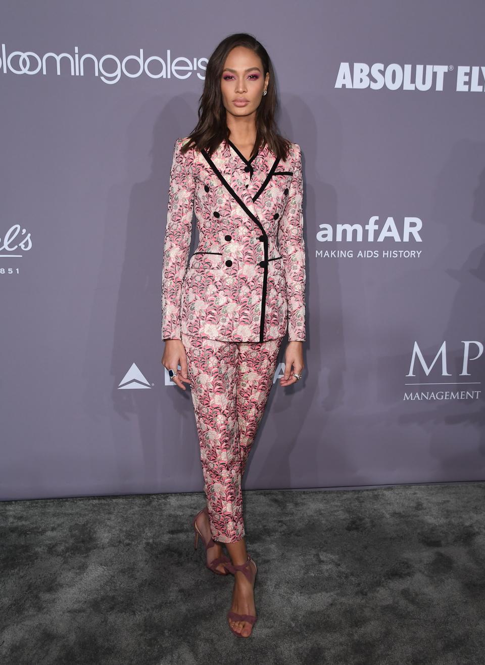 <p>Joan Smalls tanzte mit einem blumigen Hosenanzug aus der Reihe. Der Anzug von Dolce & Gabbana bekam durch silberfarbene Stickereien seinen festlichen Touch. Knallpinker Eyeshadow betonte die strahlenden Augen des Models. (Bild: Getty Images) </p>