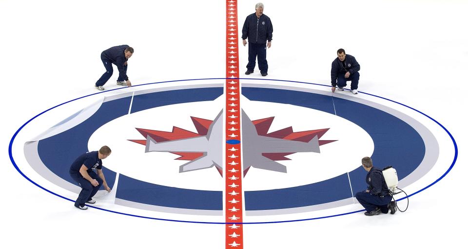 WINNIPEG, CANADA - JANUARY 8: Ice technicians install the Winnipeg Jets logo at centre ice at the MTS Centre on January 8, 2013 in Winnipeg, Manitoba, Canada. (Photo by Marianne Helm/Getty Images)