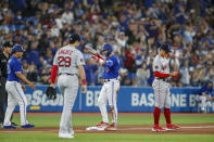 Toronto Blue Jays' Whit Merrifield (1) celebrates as he takes third base on a single with the help of a throwing error by Boston Red Sox catcher Connor Wong (not shown) in the fourth inning of a baseball game in Toronto, Sunday, Oct. 2, 2022. (Cole Burston/The Canadian Press via AP)