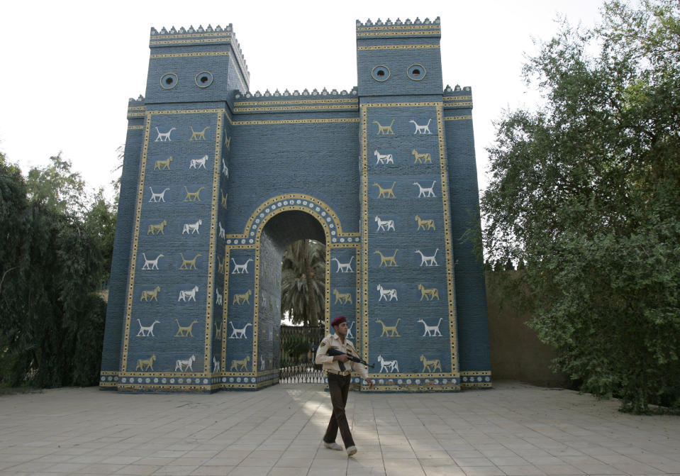 FILE - In this Sept. 18, 2008 an Iraqi armed soldier walks in front of Ishtar Gate of ancient Babylon, Iraq. Iraq is celebrating UNESCO's World Heritage Committee's naming the historic city of Babylon a World Heritage Site in a vote in Azerbaijan. Friday's vote comes after Iraq bid for years for Babylon to become a World Heritage Site. (AP Photo/Karim Kadim, File)