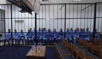 Officials of Muammar Gaddafi's government sit behind bars during a hearing at a courtroom in Tripoli April 14, 2014. REUTERS/Ismail Zitouny