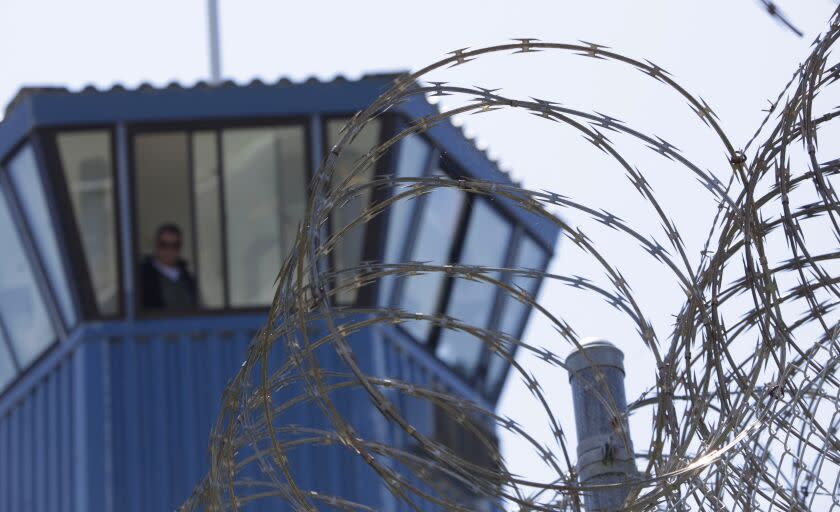 FILE - In this Aug. 17, 2011, file photo, concertina wire and a guard tower are seen at Pelican Bay State Prison near Crescent City, Calif. Federal prosecutors say leaders of a notorious white supremacist gang have been charged with directing killings and drug smuggling from within California's most secure prisons. The charges unsealed Thursday, June 6, 2019, detail five slayings and accuse an attorney of helping smuggle drugs and cell phones. (AP Photo/Rich Pedroncelli, File)