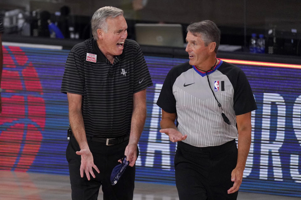 Houston Rockets head coach Mike D'Antoni, left, gestures as he talks to official Scott Foster, right, during the first half of an NBA first-round playoff basketball game against the Oklahoma City Thunder in Lake Buena Vista, Fla., Wednesday, Sept. 2, 2020. (AP Photo/Mark J. Terrill)