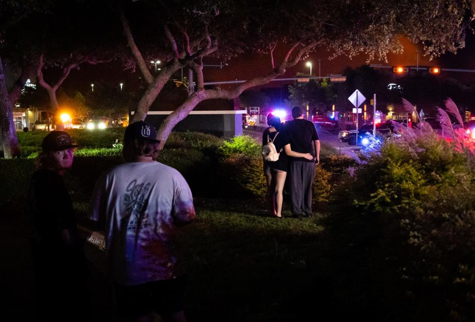 Nearby residents watch as fire crews and safety officials respond to a grass fire in Cedar Park near Parmer Lane, Aug. 9, 2023.