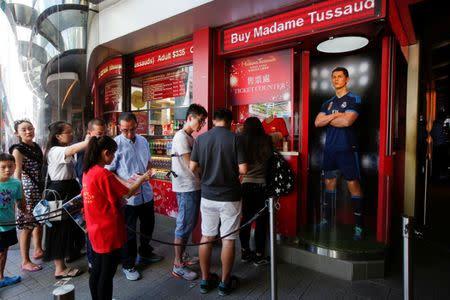 FILE PHOTO - Tourists line up to buy tickets for Madame Tussauds beside a wax figure of soccer player C. Ronaldo in Hong Kong, China August 4, 2017. REUTERS/Bobby Yip