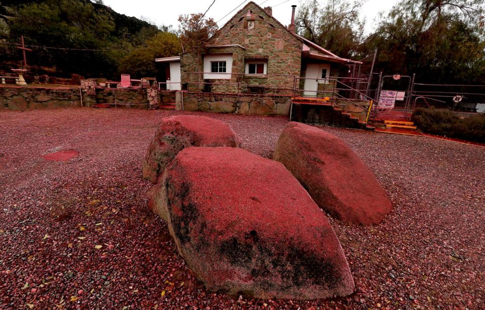 Large pink stones rise in the foreground while a slightly stained home can be seen in the background.